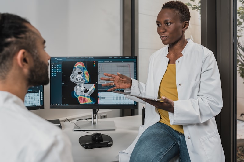 Radiologists reviewing CT and MRI scans on workstation